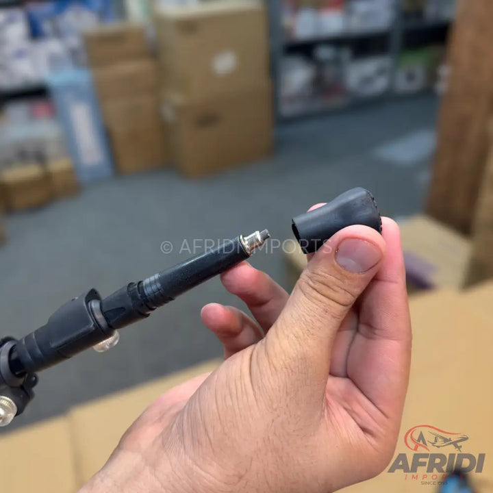 A black automotive spark plug or ignition coil boot.