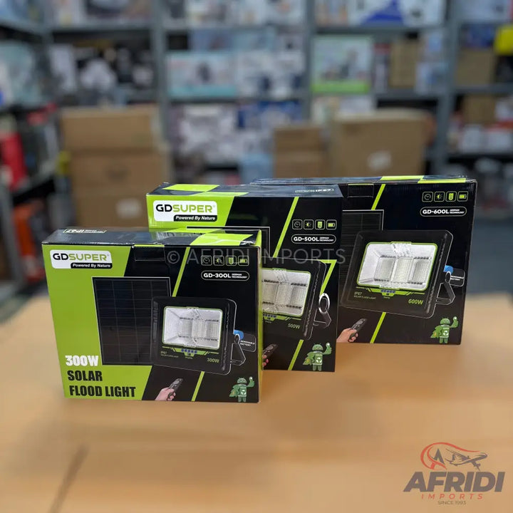 Three GD SUPER solar flood lights in their packaging, showing different wattages.