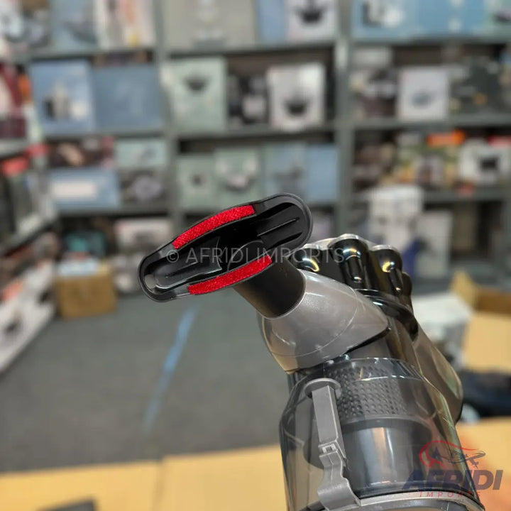 A handheld vacuum cleaner with red brush bristles.