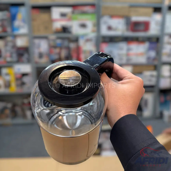 Clear glass kettle with a black lid and handle.