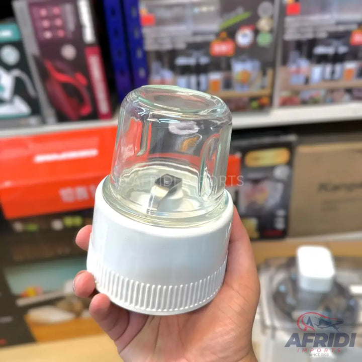 A compact white and glass electric grinder with a blade.
