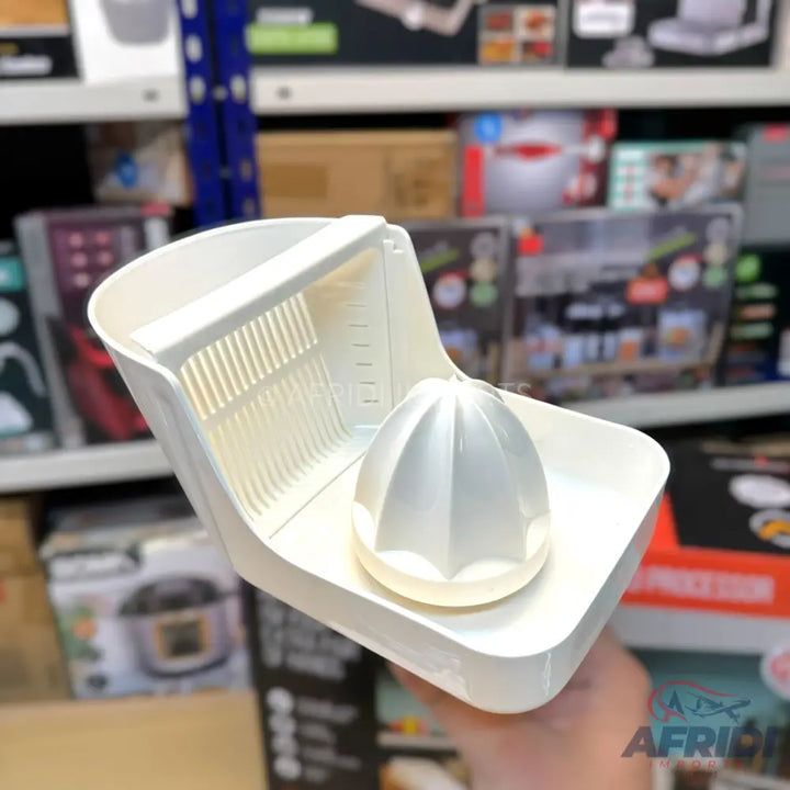 White plastic manual citrus juicer with a built-in strainer and measuring marks.