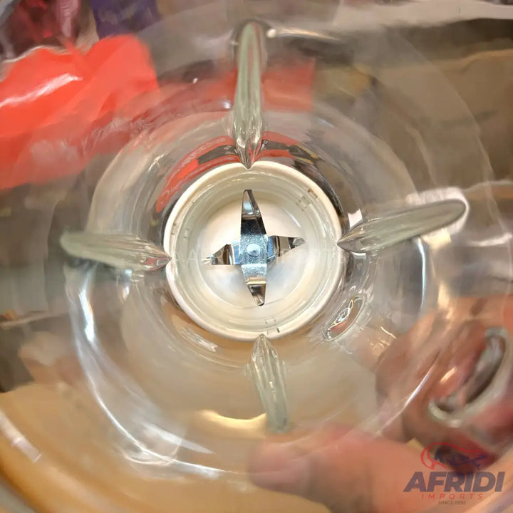 The interior of a blender with a four-pronged blade.