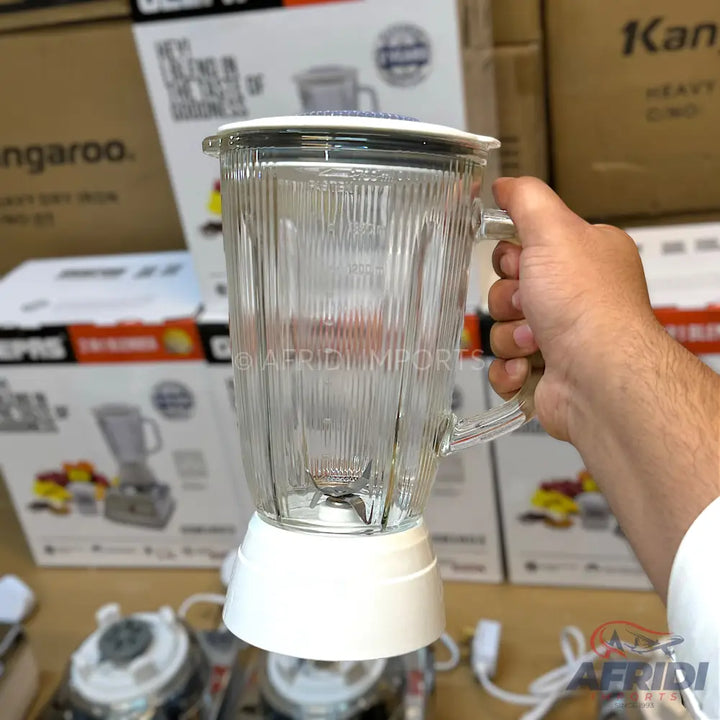 A clear glass blender jar with a white base and lid, featuring vertical ridges.