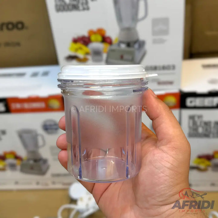 A clear plastic blender cup with a white lid and internal blades.