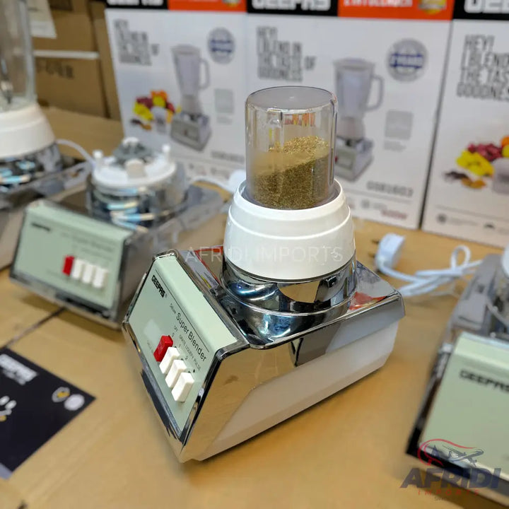 A white and chrome electric blender with a transparent grinding cup containing ground spices.