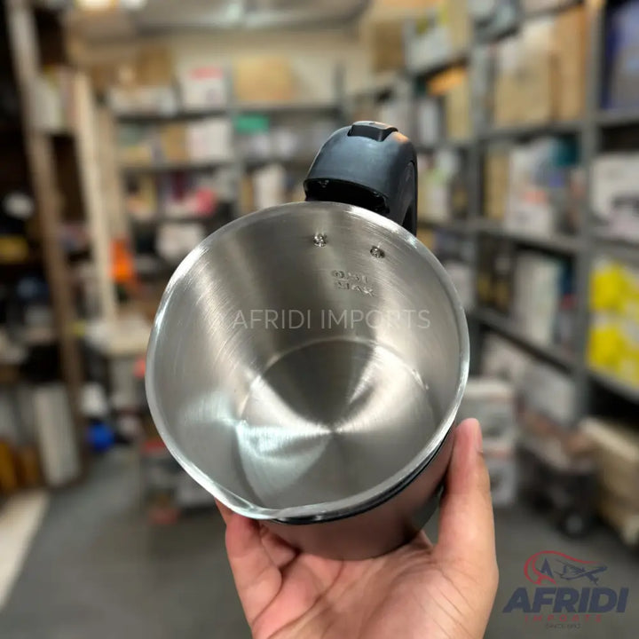 Stainless steel electric kettle with a black handle.