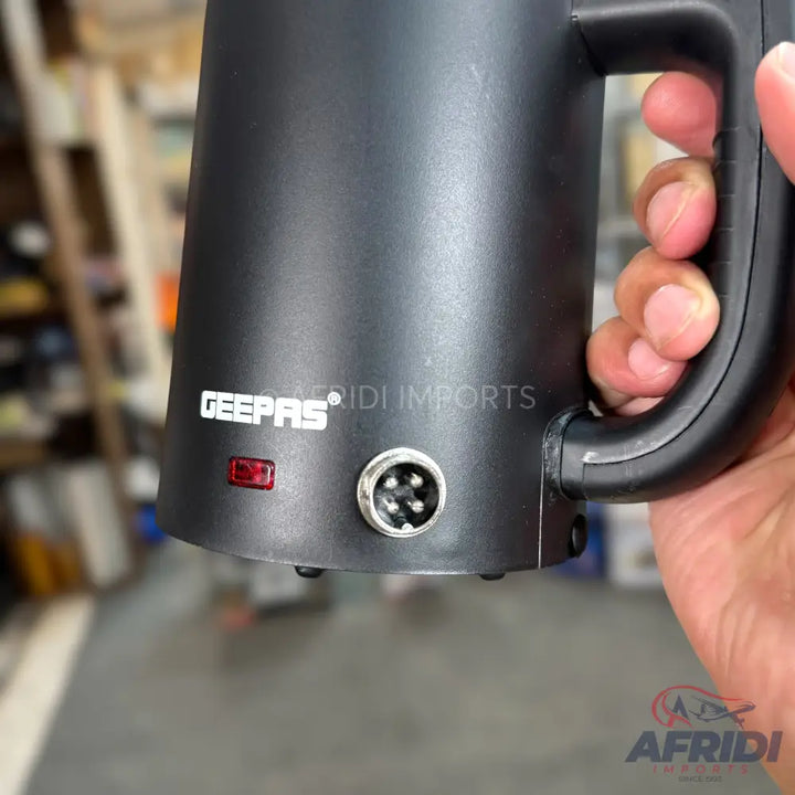 Black travel mug or portable kettle with a handle and power input.