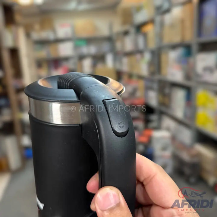 Black travel mug with a pour-over lid and a handle featuring a button.