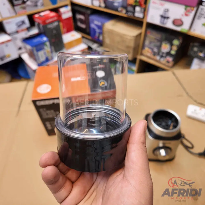 A clear plastic blender cup with a black base and integrated blades.
