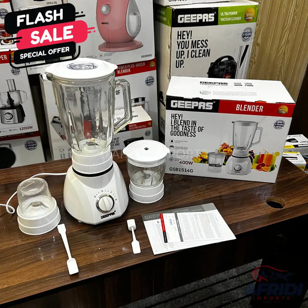White blender with glass jar and two grinding attachments.