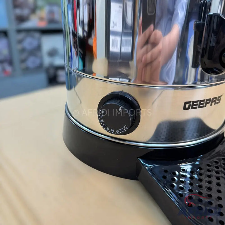 A shiny silver and black hot water dispenser with a temperature control knob and a dispensing tap.