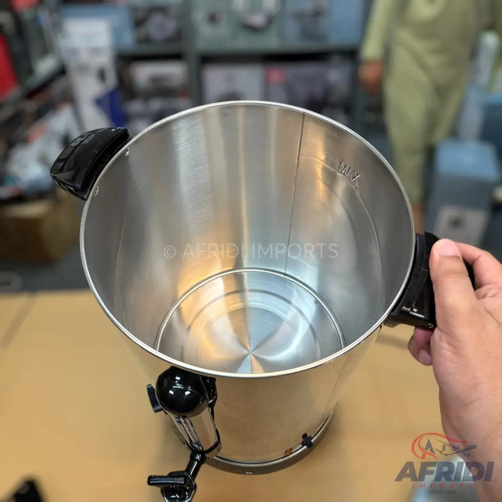 Stainless steel electric hot water urn with a spigot and side handles.