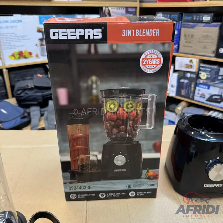 A black blender with three attachments, including a main pitcher filled with fruit, offering two speeds and pulse function, with a stainless steel blade and a 2-year warranty.