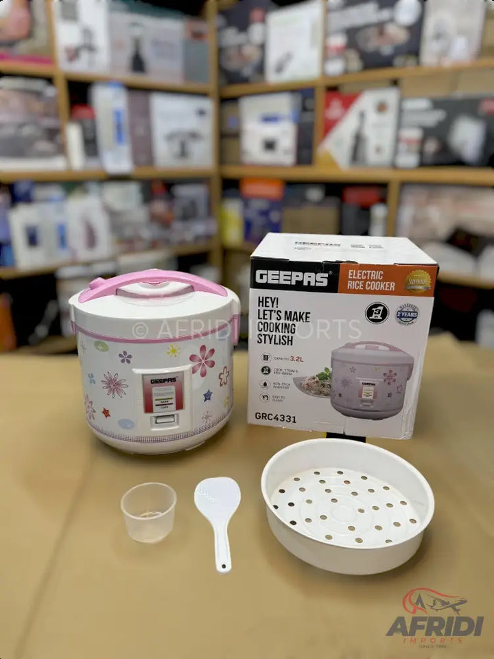 White electric rice cooker with pink accents and floral patterns.