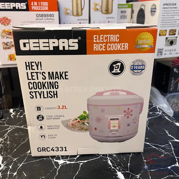 A boxed pink electric rice cooker with a 3.2L capacity, non-stick inner pot, and a 2-year warranty.
