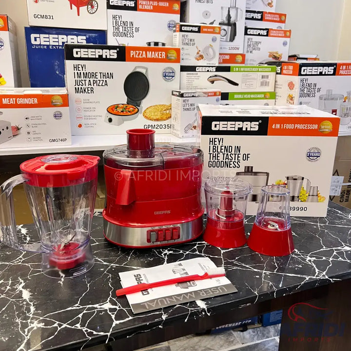 Red kitchen food processor with blender and grinder attachments.