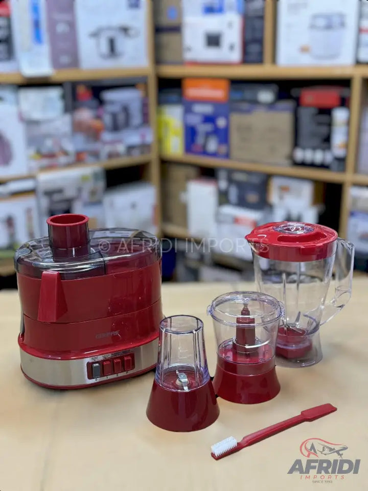 Red food processor with multiple attachments.
