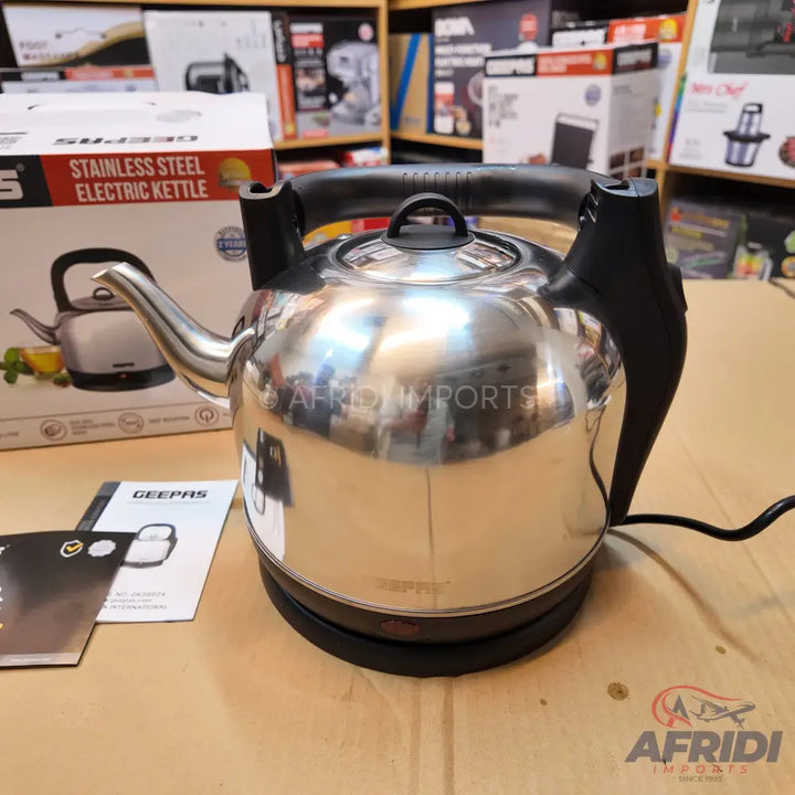 Shiny stainless steel electric kettle with a black handle.
