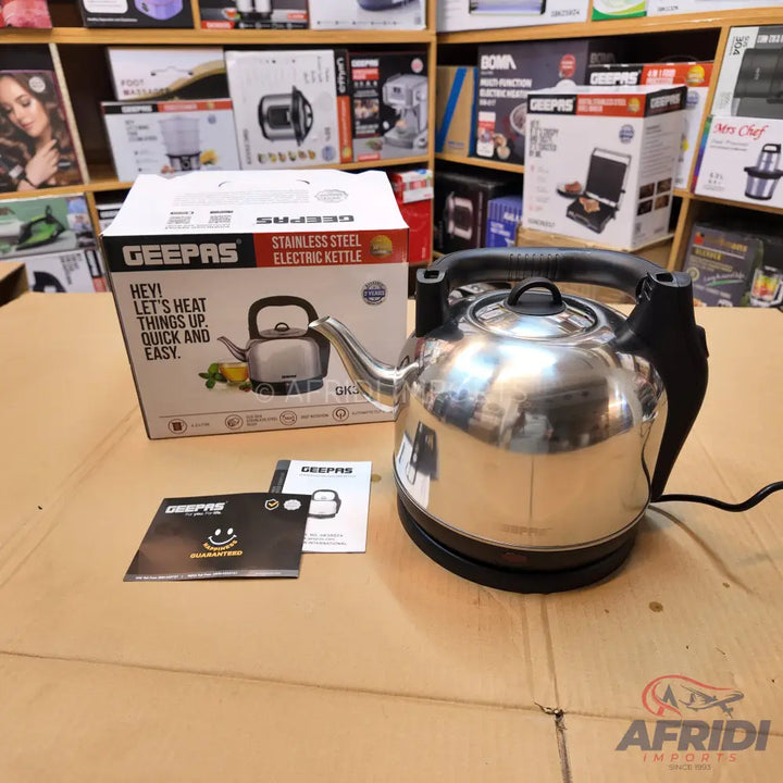 Stainless steel electric kettle with a black handle.