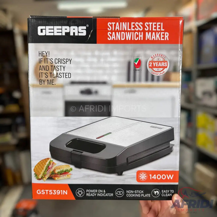A silver and black stainless steel sandwich maker with 1400W power, a non-stick cooking plate, and a power on/ready indicator.
