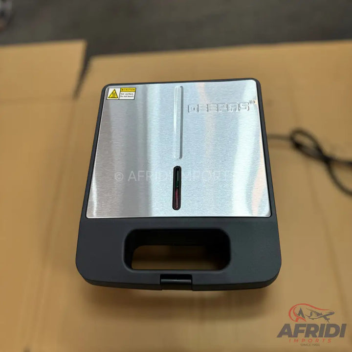 A stainless steel and black electric sandwich maker.