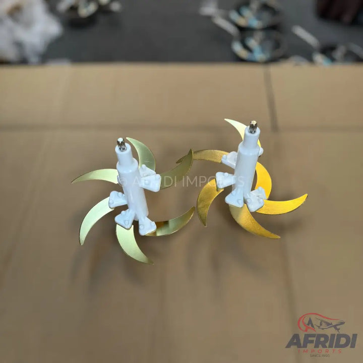 Two white and gold rotating blades for a food processor or blender.