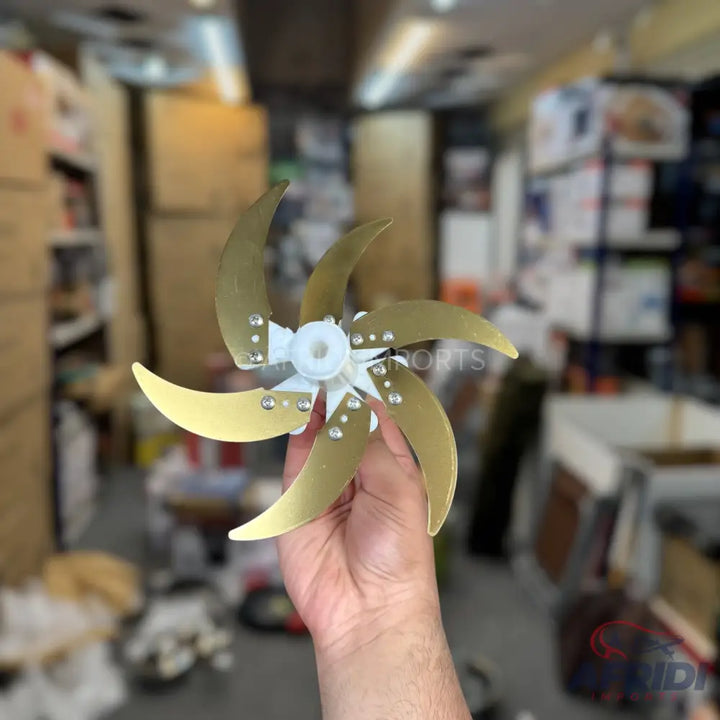 Six-bladed brass fan impeller with a white plastic hub.