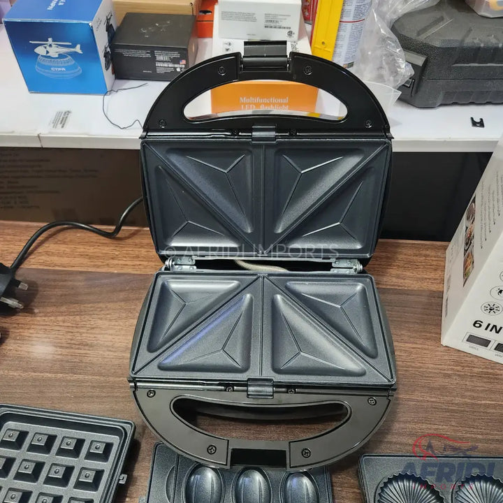 An open sandwich maker with interchangeable plates for various treats.