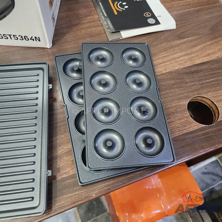 Interchangeable cooking plates for a multi-functional kitchen appliance, including a ribbed grill plate and two donut molds.