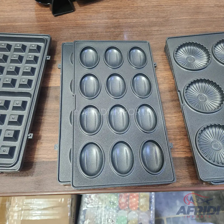 Interchangeable non-stick baking plates for a waffle maker, featuring waffle, nut, and tartlet patterns.