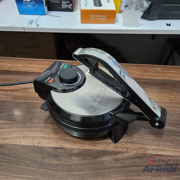 A black and silver electric griddle or waffle maker with a temperature control knob.