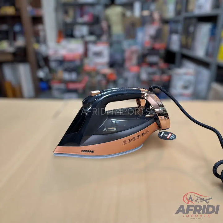A black and rose gold steam iron with a black power cord.