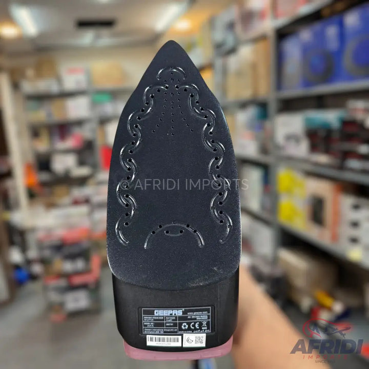 Black and pink steam iron with a patterned soleplate.