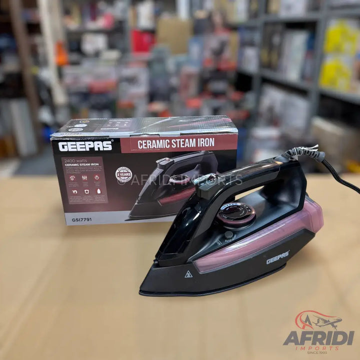 Black and pink ceramic steam iron with its product box.