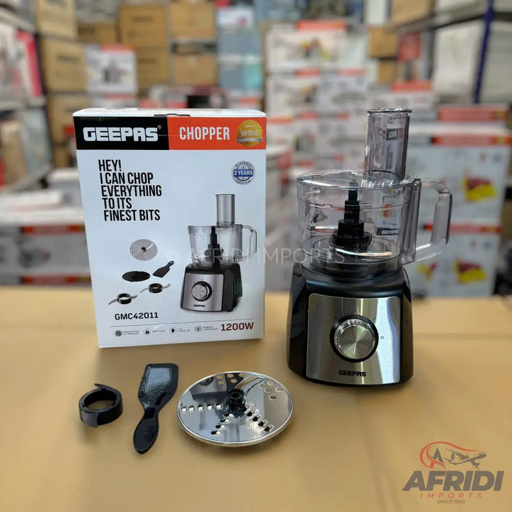 A black and silver Geepas chopper with a 1200W motor, including a clear processing bowl, lid, and various blades for chopping and slicing.