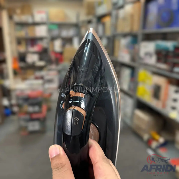 A black and rose gold steam iron with a pointed tip, featuring a textured handle and visible controls for steam and temperature settings.