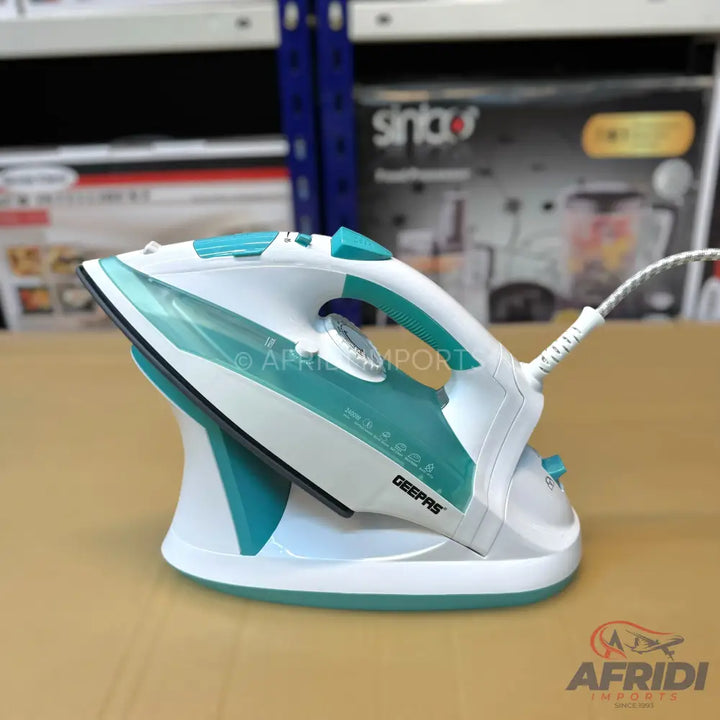 White and teal cordless steam iron with a charging base.