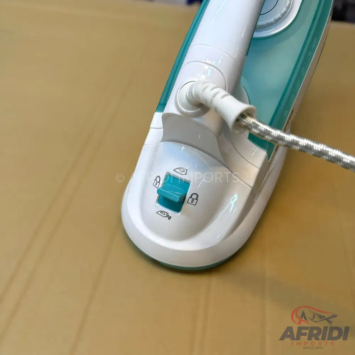 A white and teal handheld garment steamer with a locking switch and braided power cord.