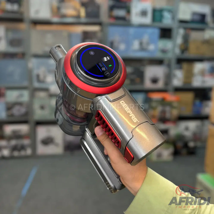 A handheld cordless vacuum cleaner with a digital display.