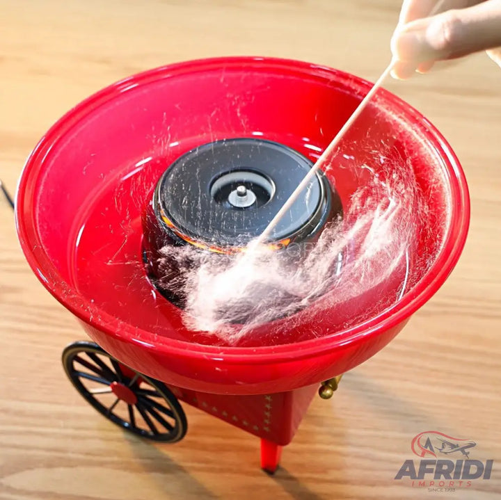 Red cotton candy machine with a black spinning head, actively making white cotton candy.