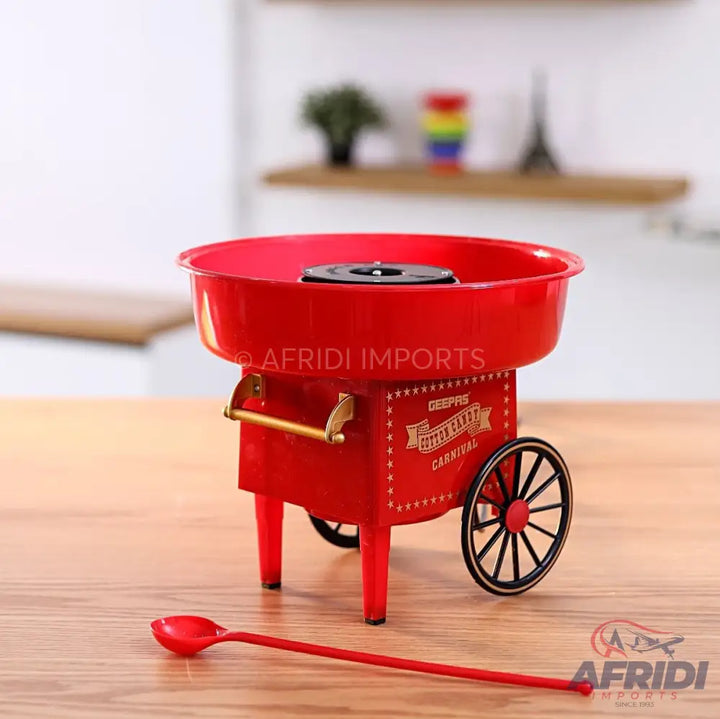 Red vintage-style cotton candy maker with wheels and a measuring spoon.