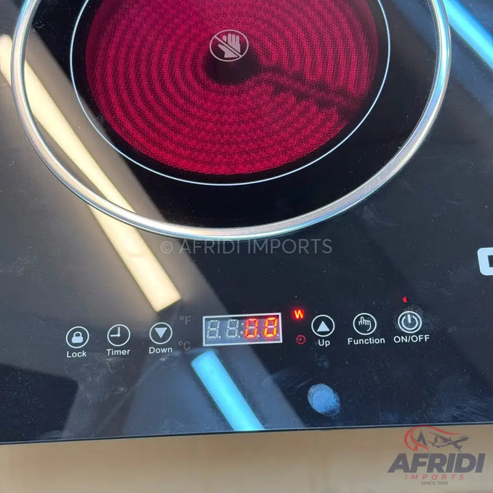 Black glass-top induction cooktop with red heating elements and digital controls.