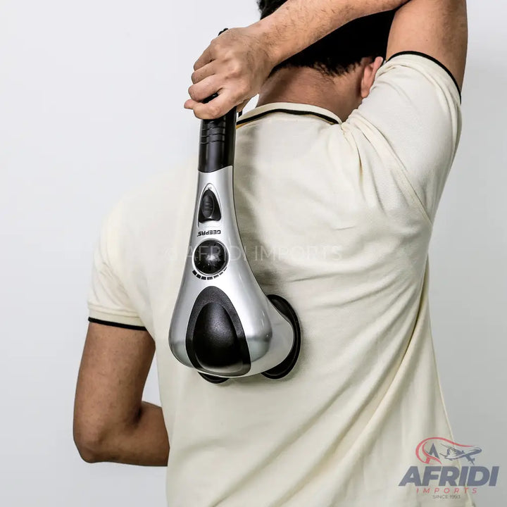 A handheld percussive massager being used on a person’s back.