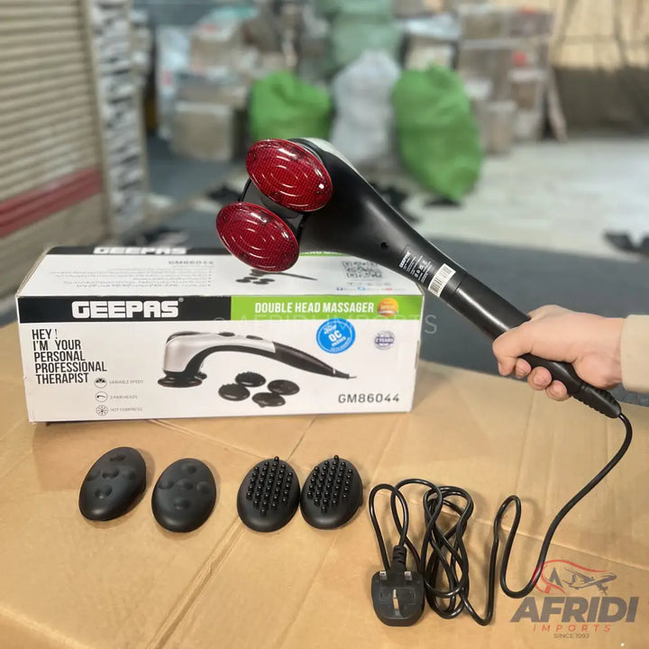 Black handheld double-head massager with red rotating heads and interchangeable attachments.
