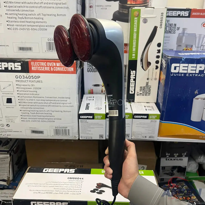 Handheld percussive massager with two red, rotating massage heads.