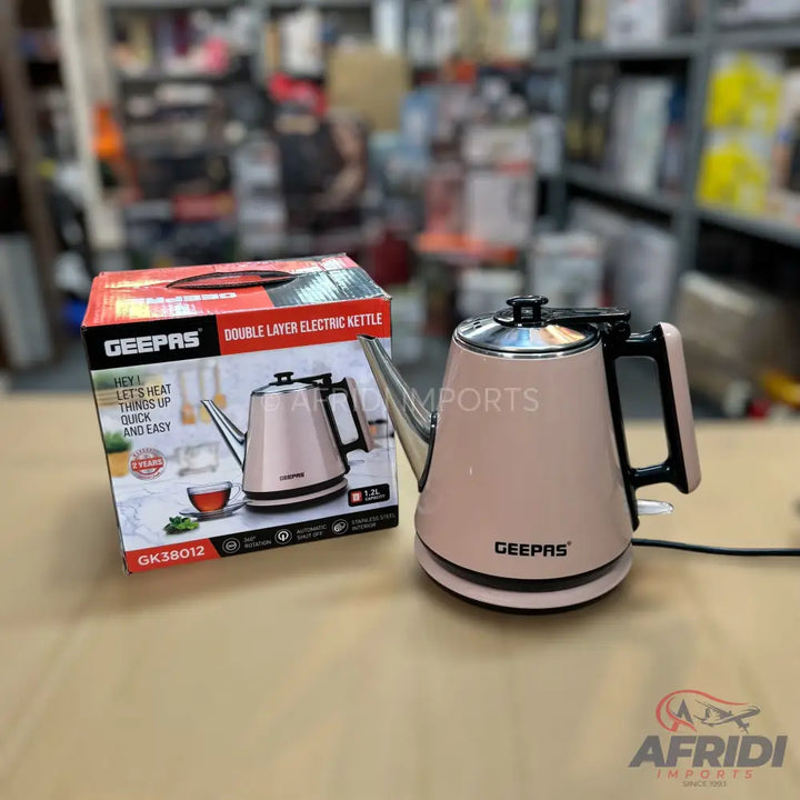 A pink double-layer electric kettle with a black handle and a silver spout, accompanied by its product box.