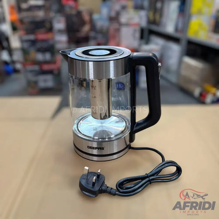 A glass and stainless steel electric kettle with a UK plug.