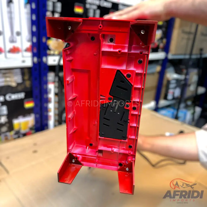 Red plastic casing for an electronic device, with internal compartments and screw holes.
