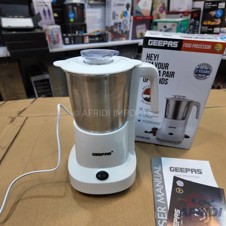 A white Geepas food processor with a stainless steel pitcher and a user manual.